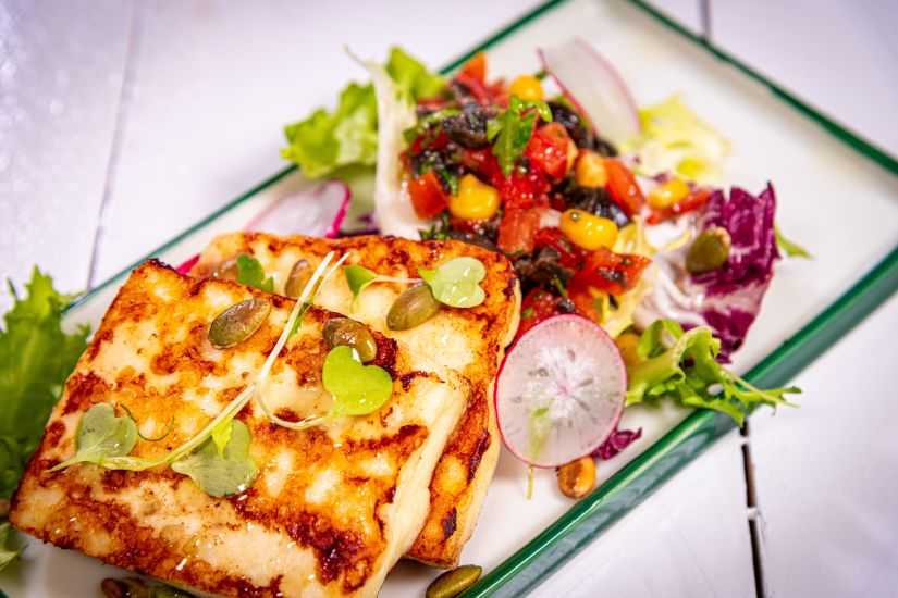 Halloumi cu mix de semințe, salsa de roșii, măsline, porumb și mix de salată