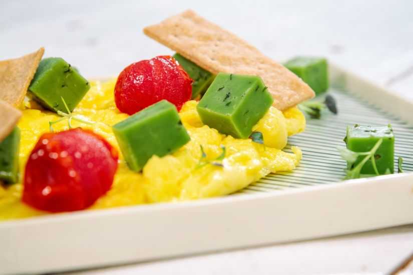 Scramble cu verdeață, roșii cherry, brânză maturată cu pesto și crackers cu semințe